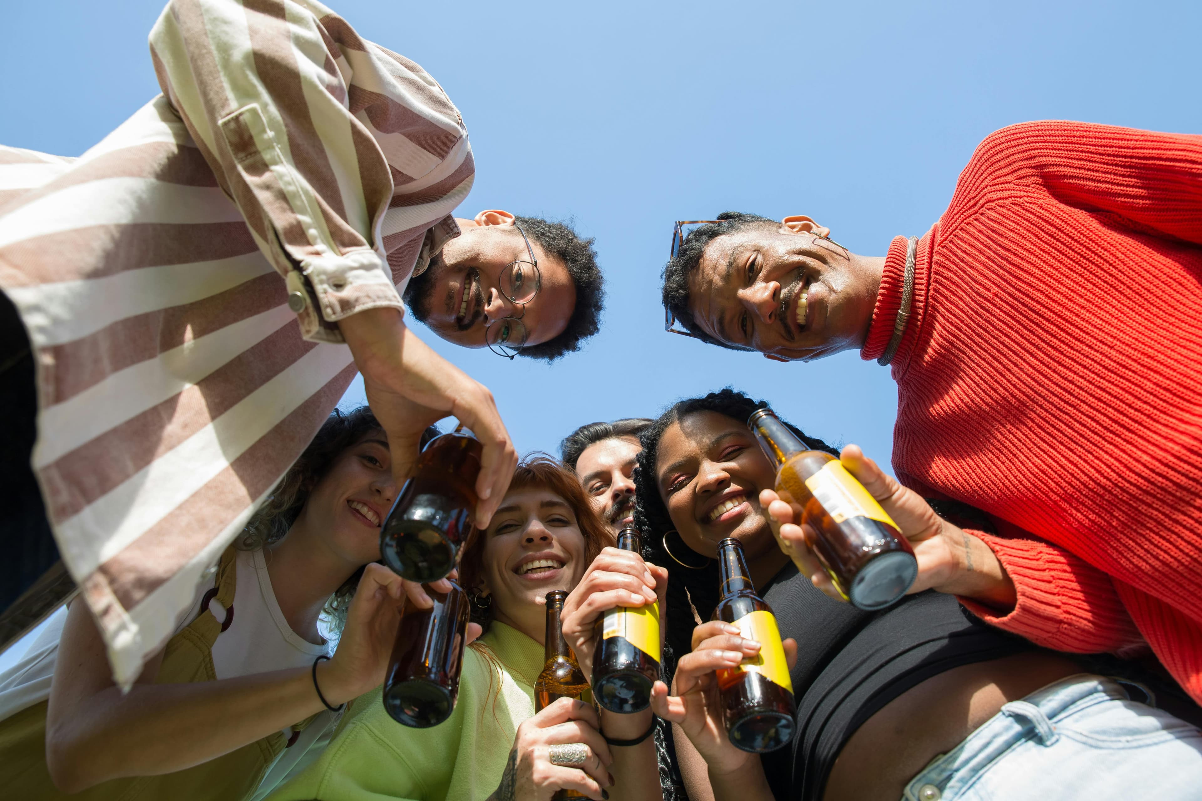 Two people in a crowd drinking a beer