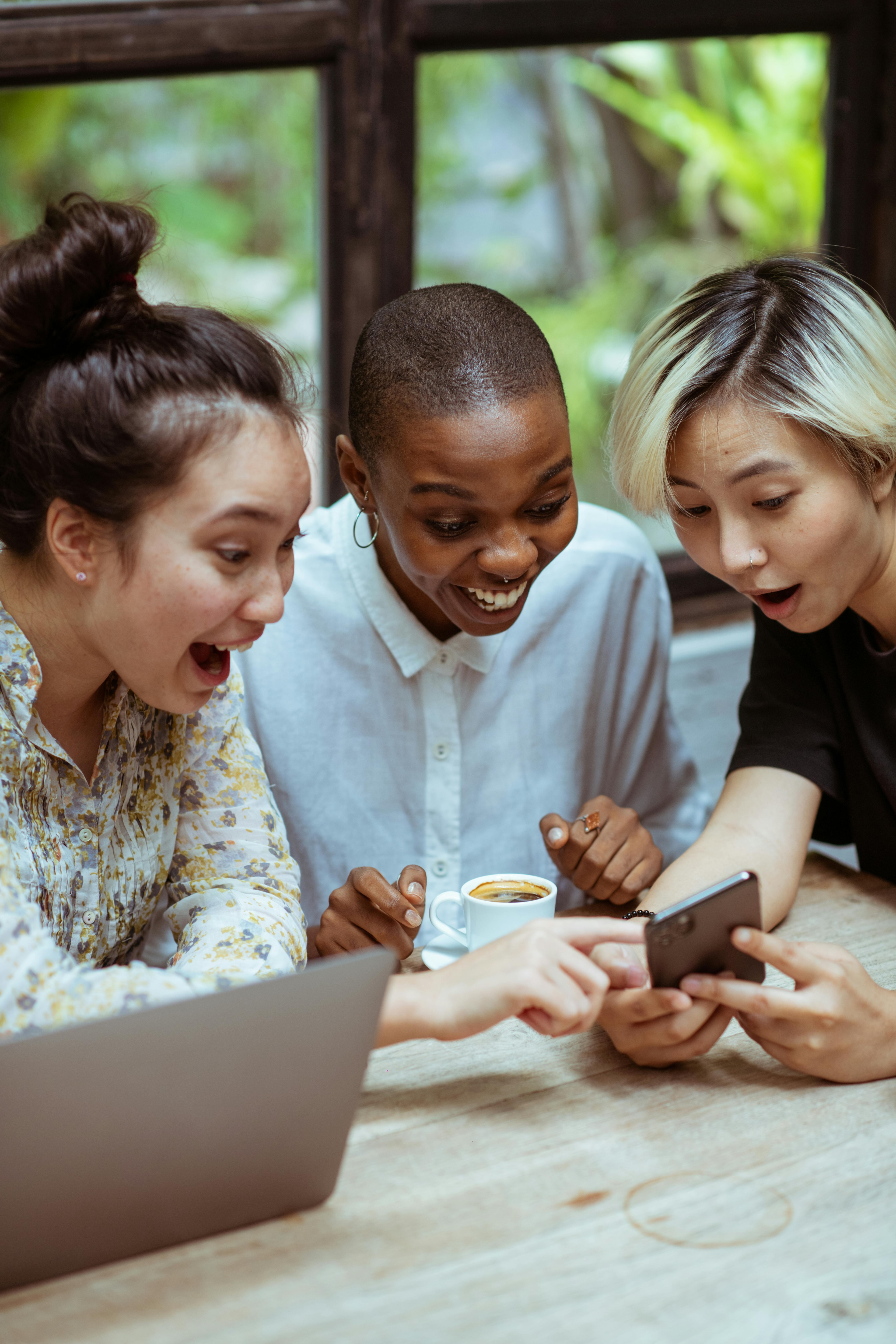 Three people interacting with a phone