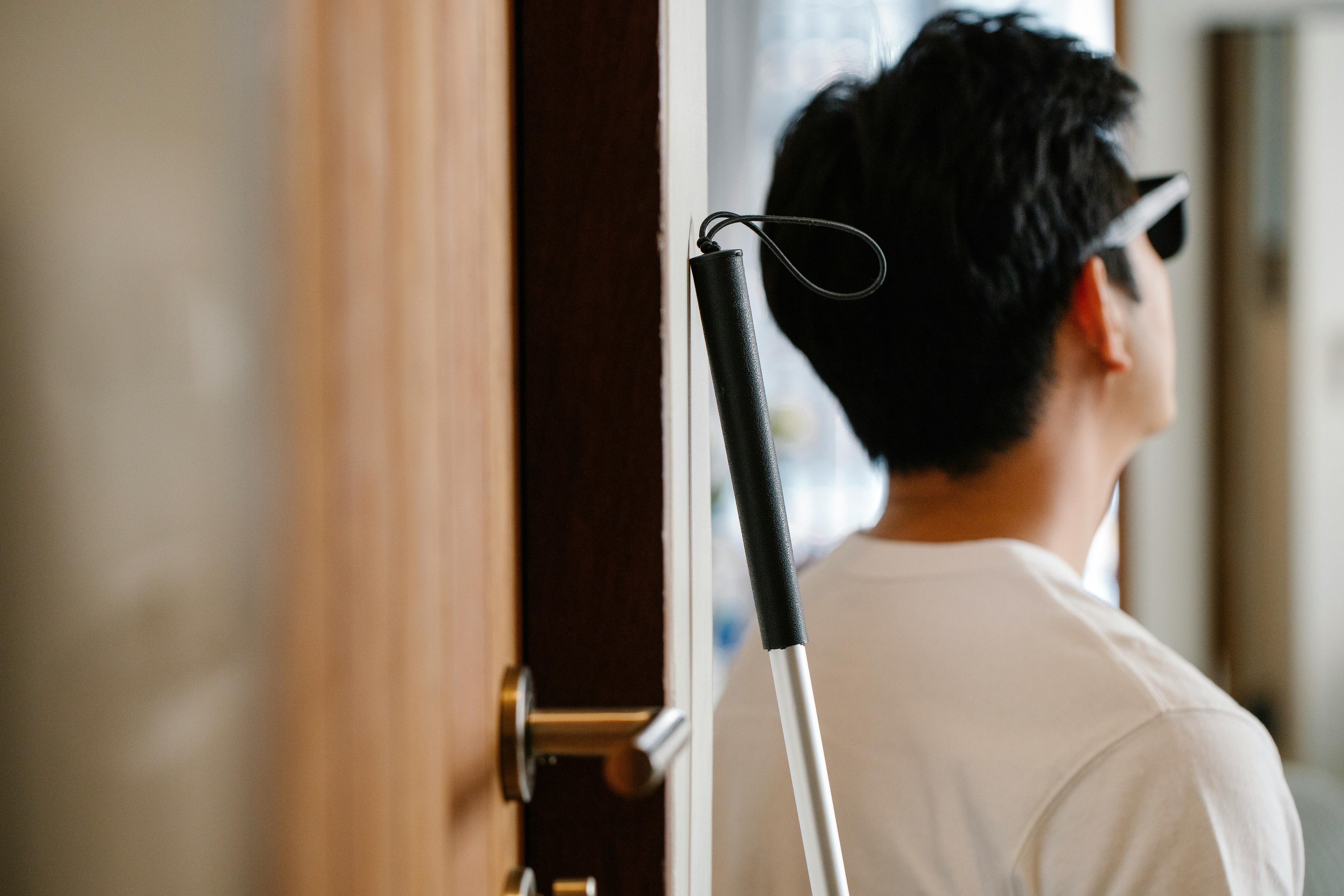 A man standing by a door with his walking aid