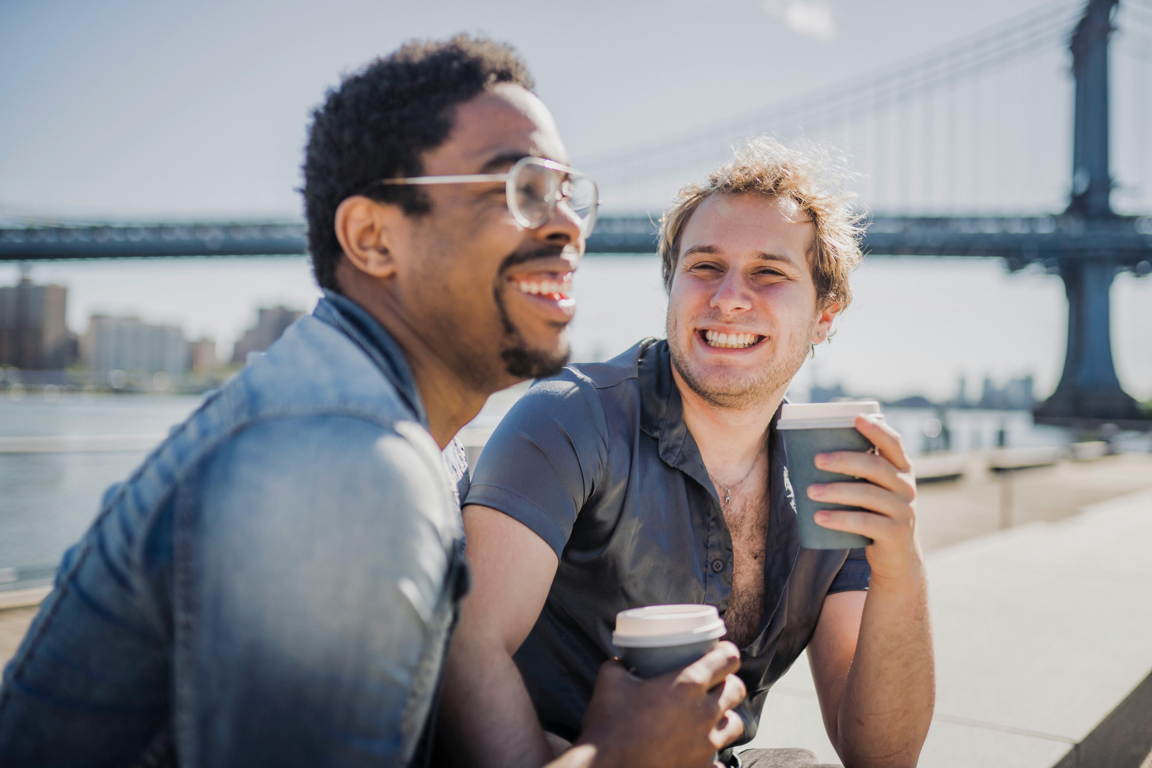 Two men having coffee on a board walk