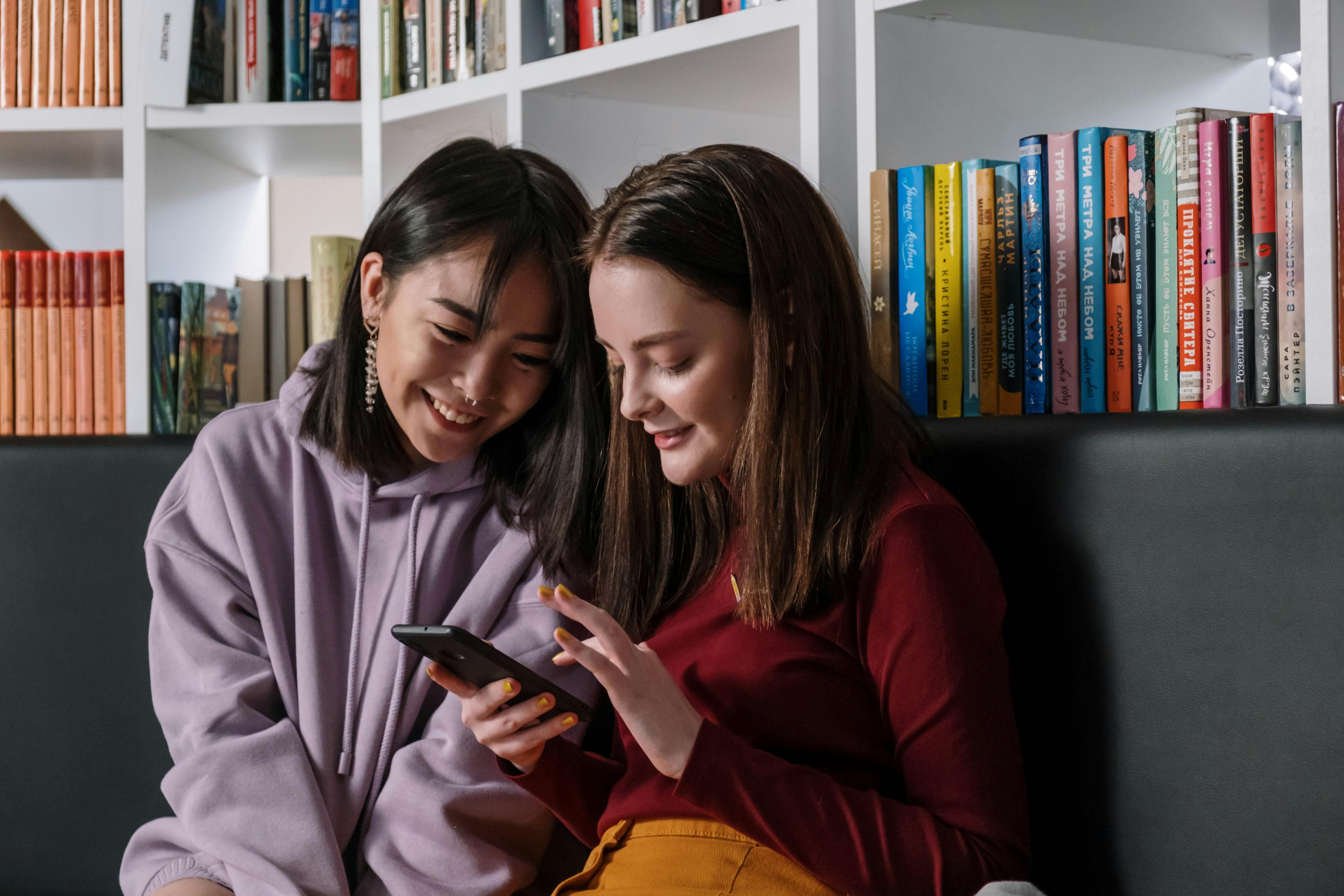 Two girls interacting with their phone